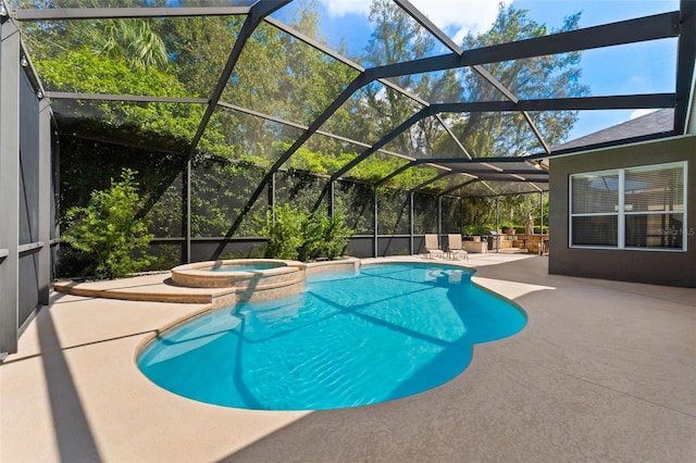 view of pool with an in ground hot tub, a patio area, and glass enclosure