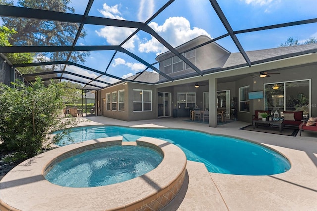 view of swimming pool with glass enclosure, an in ground hot tub, ceiling fan, and a patio