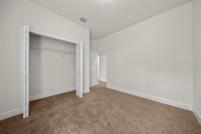 unfurnished bedroom with a closet, carpet floors, and a textured ceiling