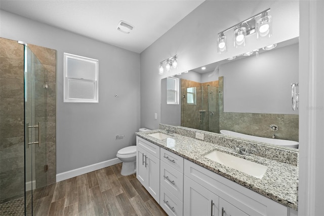 bathroom featuring hardwood / wood-style floors, vanity, toilet, and an enclosed shower