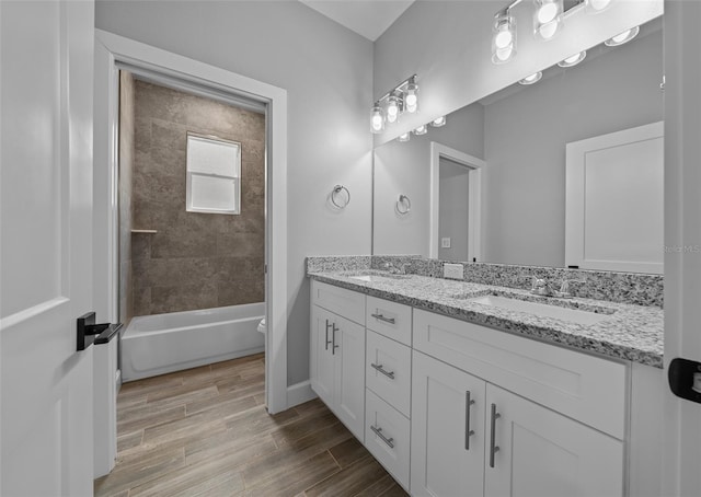 full bathroom featuring tiled shower / bath combo, vanity, toilet, and hardwood / wood-style flooring