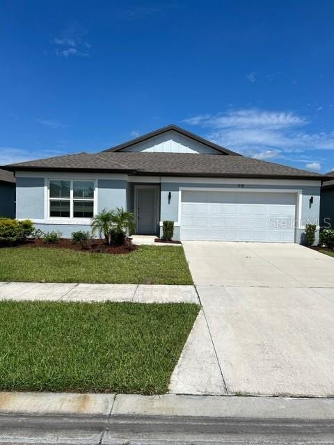 single story home with an attached garage, concrete driveway, a front yard, a shingled roof, and stucco siding