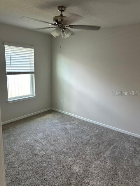 carpeted spare room with ceiling fan