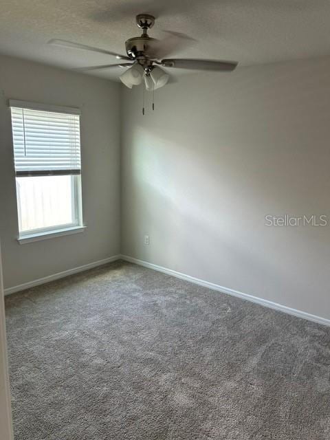 spare room featuring ceiling fan, carpet, and baseboards