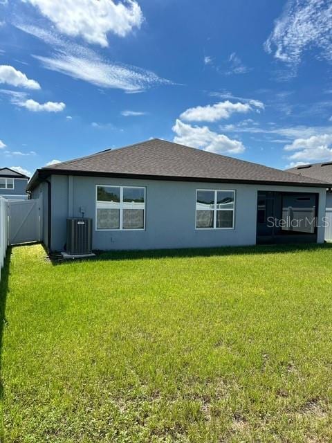 back of property with cooling unit and a lawn