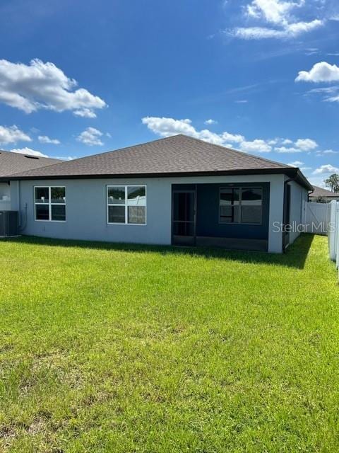 back of property featuring a yard and central AC unit