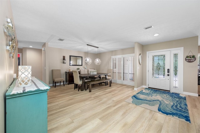 foyer entrance with a notable chandelier and light wood-type flooring