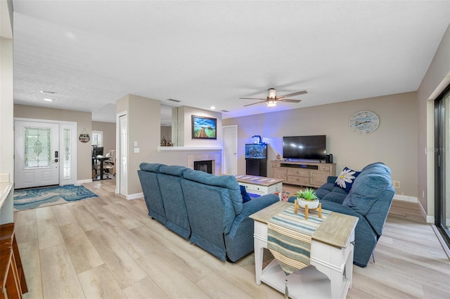 living room featuring light wood-type flooring and ceiling fan