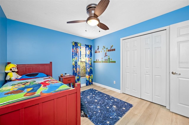 bedroom featuring ceiling fan, a textured ceiling, light hardwood / wood-style flooring, and a closet