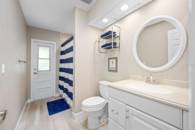 bathroom featuring vanity, hardwood / wood-style floors, and toilet