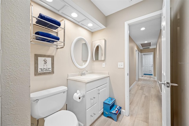 bathroom with vanity, hardwood / wood-style floors, and toilet