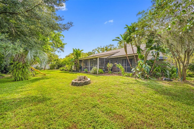 view of yard with a sunroom and an outdoor fire pit