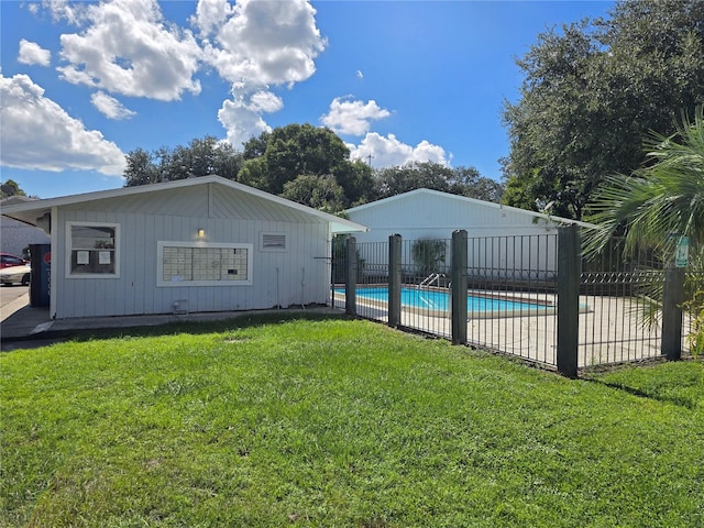 back of property featuring a fenced in pool and a yard