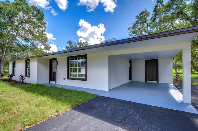 view of front facade with a front yard and a carport