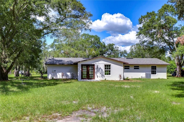 rear view of property with french doors and a lawn