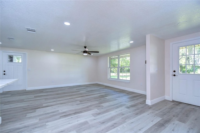 entryway with light hardwood / wood-style floors, a healthy amount of sunlight, a textured ceiling, and ceiling fan