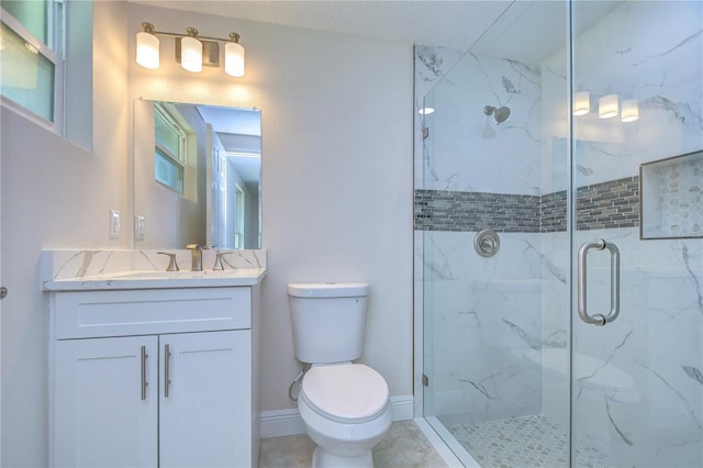 bathroom with vanity, a shower with shower door, and toilet