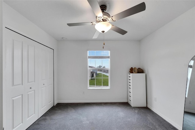 unfurnished bedroom featuring a closet, ceiling fan, and dark carpet