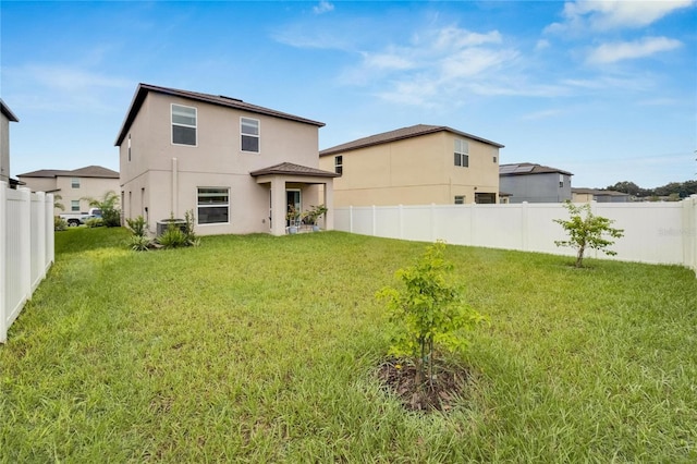 back of house with a yard and central AC unit