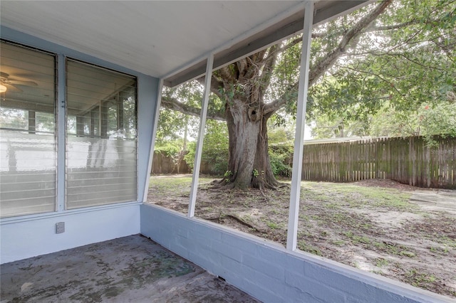 unfurnished sunroom with ceiling fan