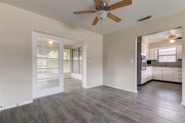 unfurnished living room with dark hardwood / wood-style flooring and sink