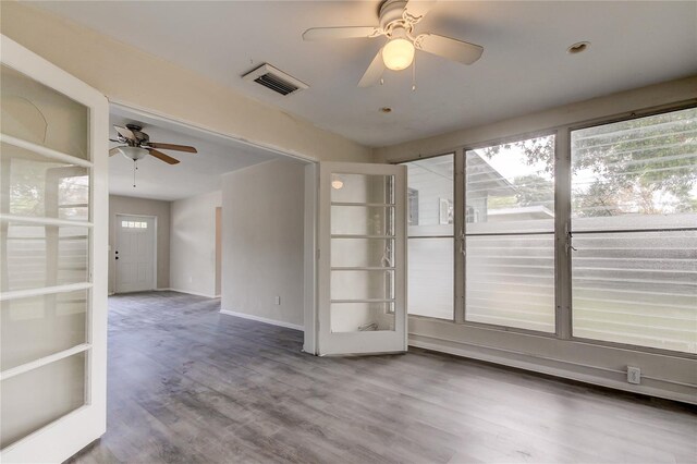 empty room with hardwood / wood-style floors and ceiling fan