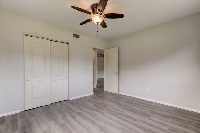 unfurnished bedroom featuring ceiling fan, light hardwood / wood-style flooring, and a closet