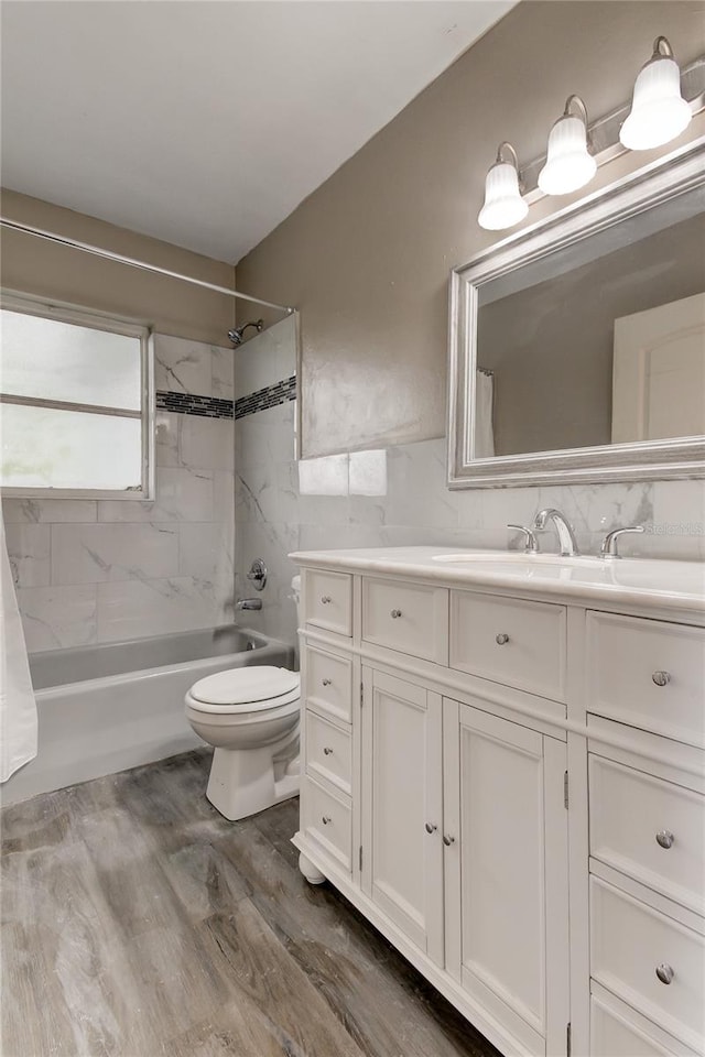 full bathroom with hardwood / wood-style floors, vanity, shower / bath combo with shower curtain, and toilet