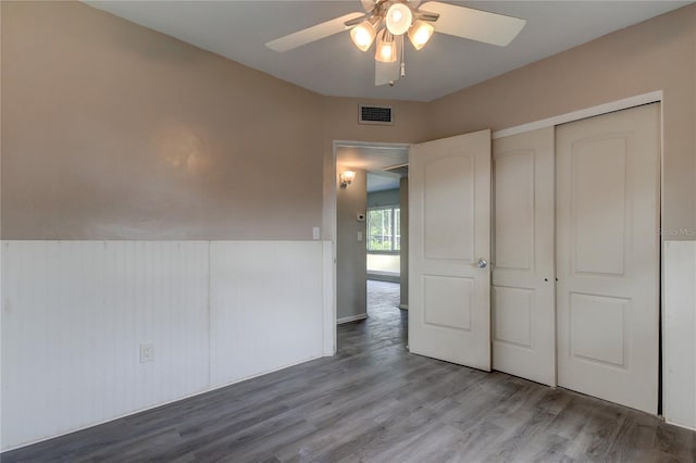 unfurnished bedroom featuring hardwood / wood-style flooring, ceiling fan, and a closet