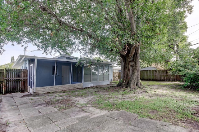 view of yard featuring a sunroom and a patio