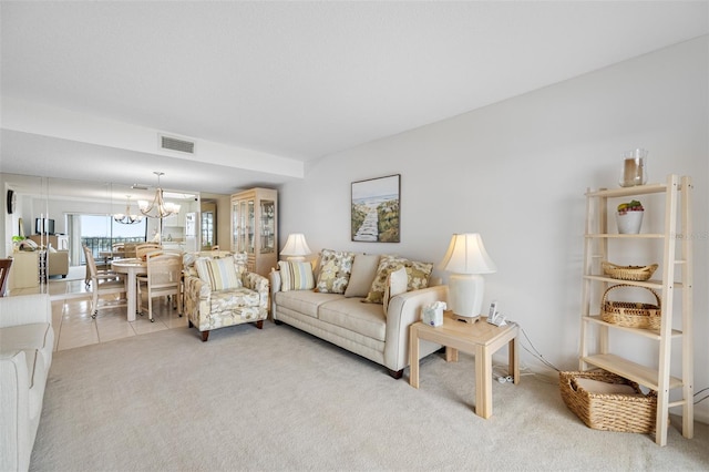 carpeted living room featuring a notable chandelier