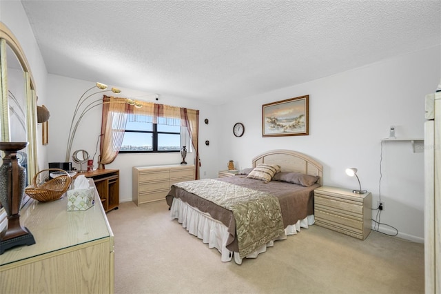 bedroom featuring light carpet and a textured ceiling