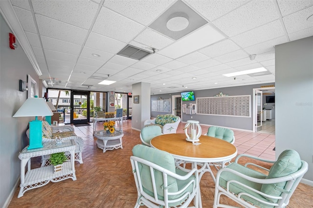 dining room featuring a drop ceiling and parquet flooring