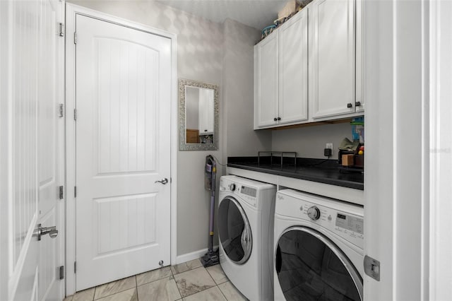 laundry area featuring washer and clothes dryer and cabinets