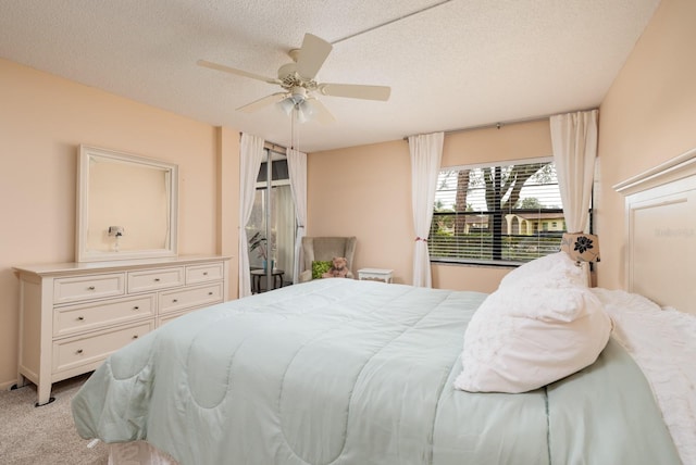 carpeted bedroom featuring ceiling fan and a textured ceiling