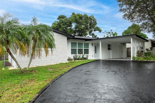 ranch-style house featuring a front yard and a carport