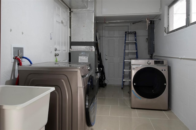 washroom featuring washing machine and clothes dryer, sink, and light tile patterned flooring