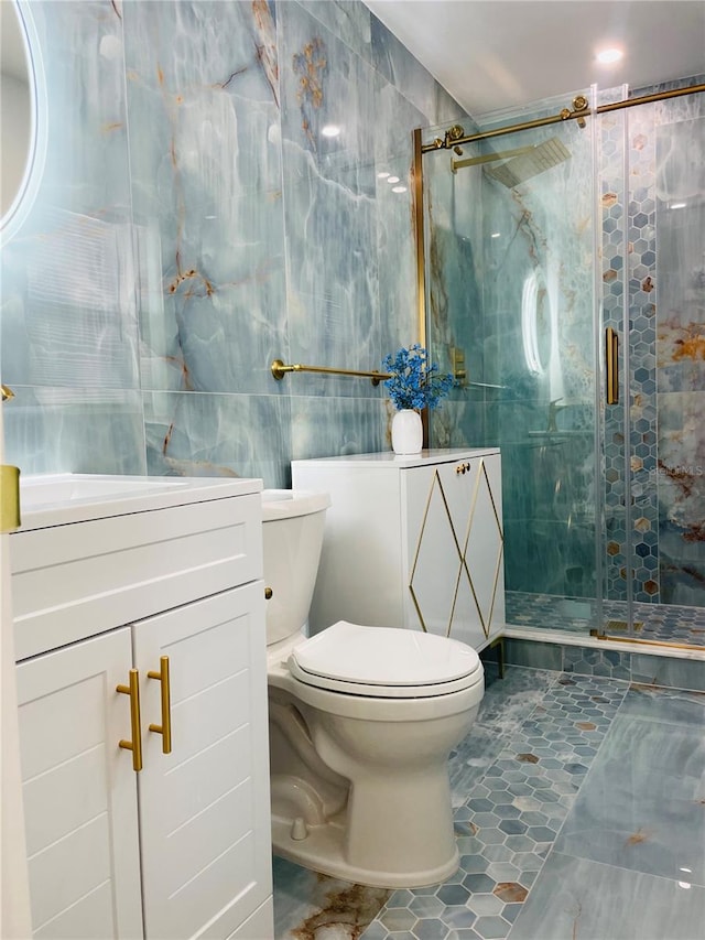 bathroom featuring an enclosed shower, vanity, tile walls, tile patterned flooring, and toilet