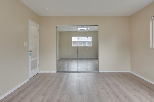 unfurnished bedroom featuring light hardwood / wood-style floors and a closet