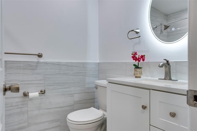 bathroom featuring vanity, toilet, and tile walls