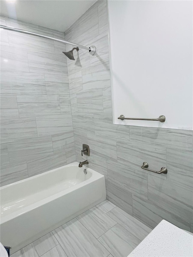 bathroom featuring tile walls and tiled shower / bath combo