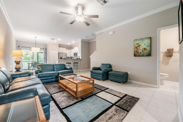 living room featuring ceiling fan, light tile patterned floors, and crown molding