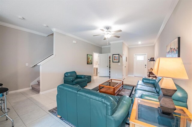 tiled living room with ceiling fan and ornamental molding