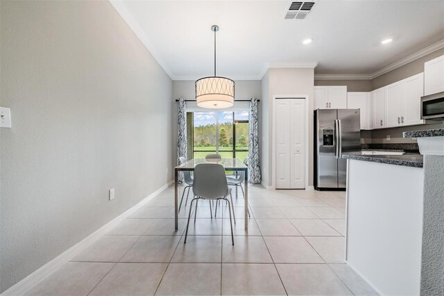 kitchen with white cabinets, hanging light fixtures, stainless steel appliances, light tile patterned floors, and crown molding