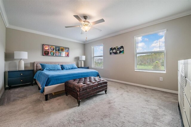 carpeted bedroom with ornamental molding and ceiling fan