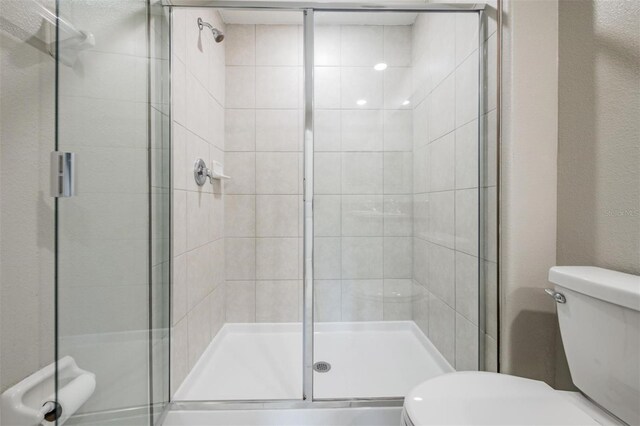 bathroom with walk in shower and toilet