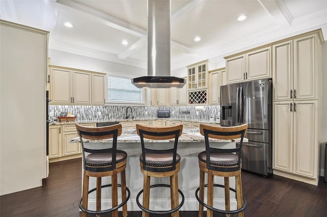 kitchen featuring cream cabinets, a center island, tasteful backsplash, and stainless steel fridge