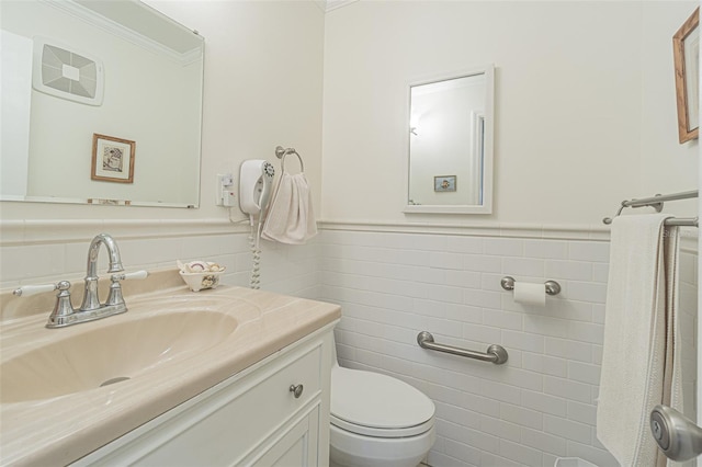 bathroom featuring tile walls, crown molding, vanity, and toilet