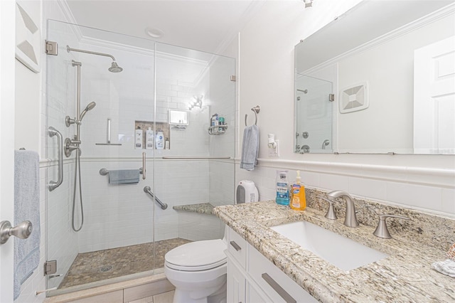 bathroom with ornamental molding, a shower with door, vanity, and toilet