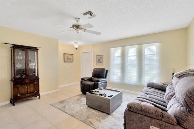 tiled living room featuring a textured ceiling and ceiling fan